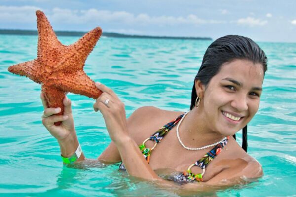 Chica con Estrella de Mar en Piscina Natural - Saona VIP - Stay Happy RD